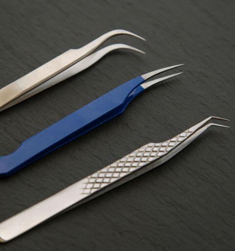 Professional eyelash tweezers used for precise lash extension application at Minh Lashes Beauty Clinic.